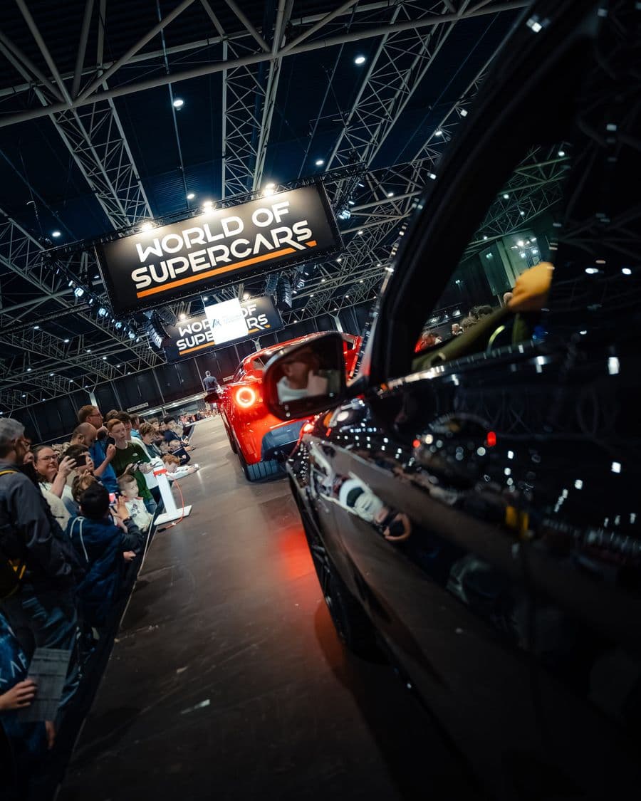 Bezoekers rond de auto’s tijdens een indoor autoshow