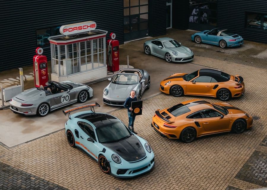 Porsches bij de klassieke benzinepomp van Porsche Centrum Gelderland