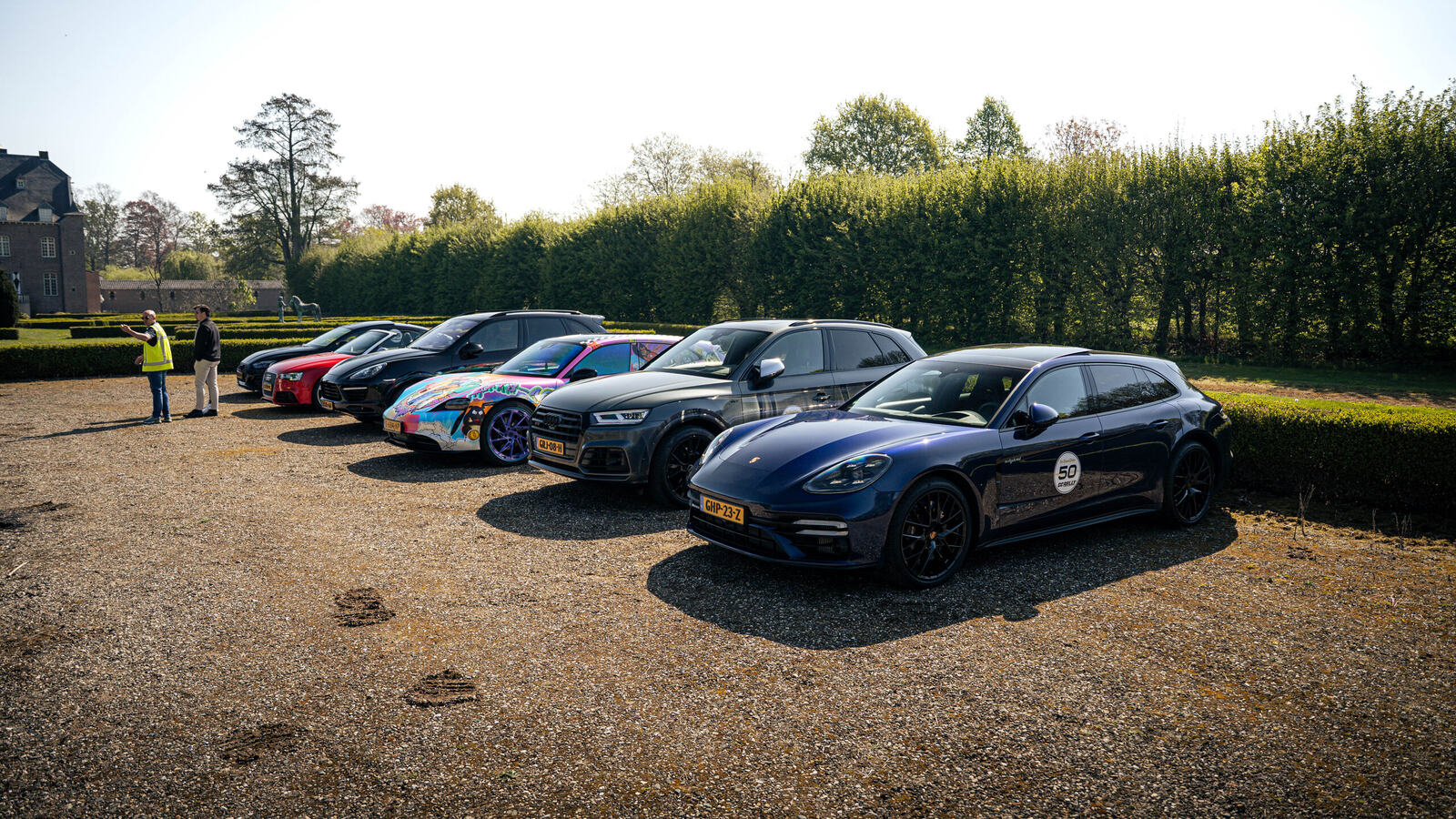 Sports cars neatly lined up at a country estate during a club gathering