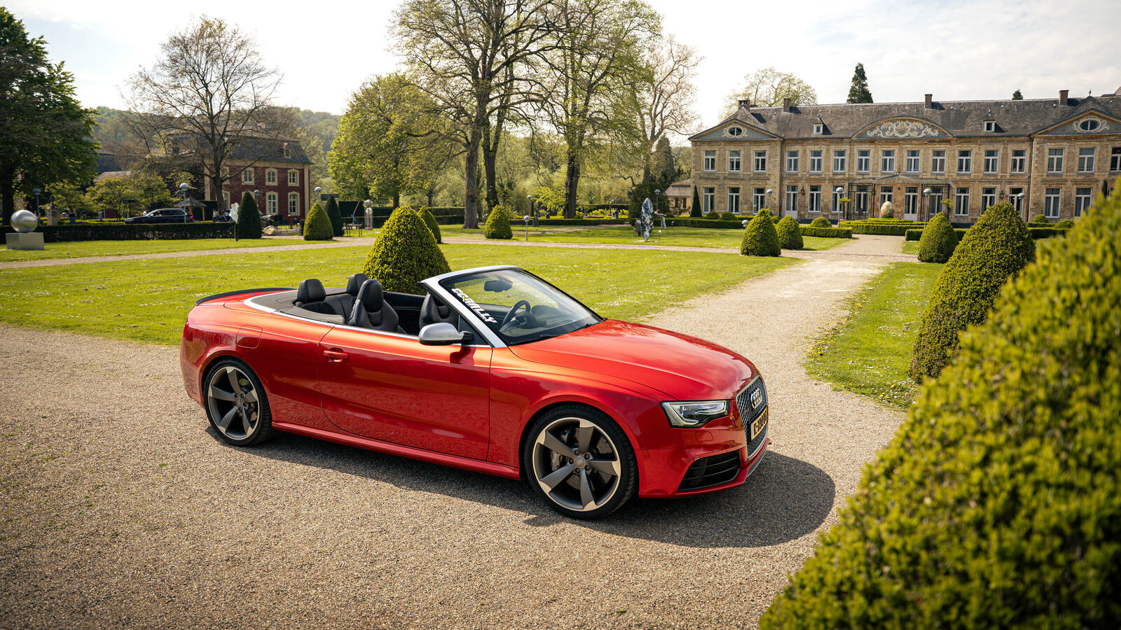 Red Audi convertible on the gravel in front of a castle, the starting point of a supercar rally in the Netherlands
