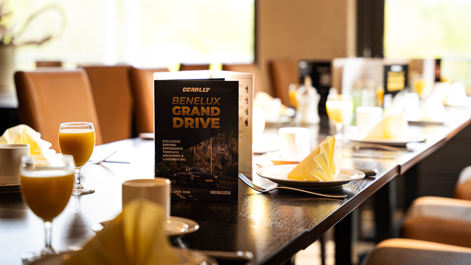 Breakfast table set with the menu of the Benelux Grand Drive, a three-day tour through three countries