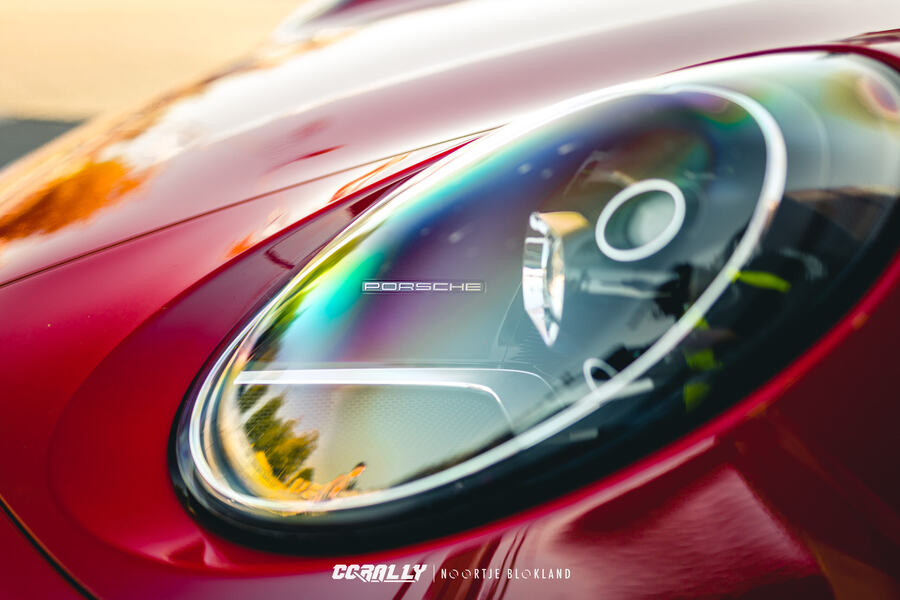 Headlight detail of a red Porsche 911 at a CCRally event