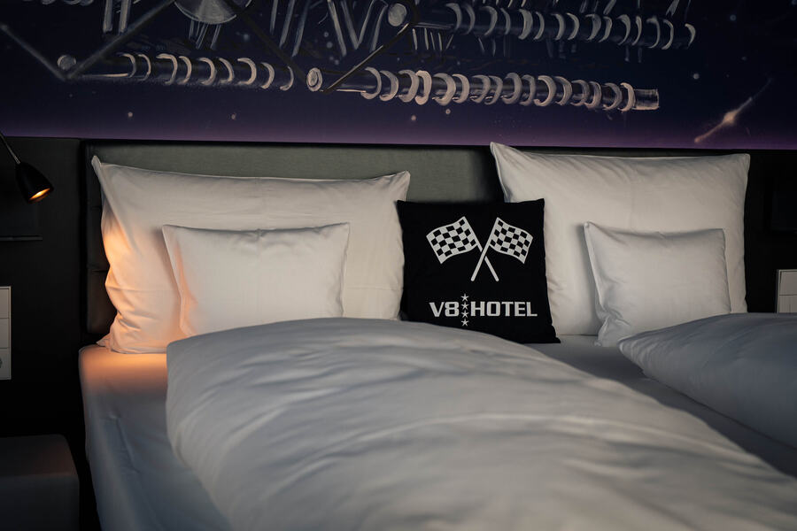 Room in a car-themed hotel with chequered-flag cushions during a multi-day drive